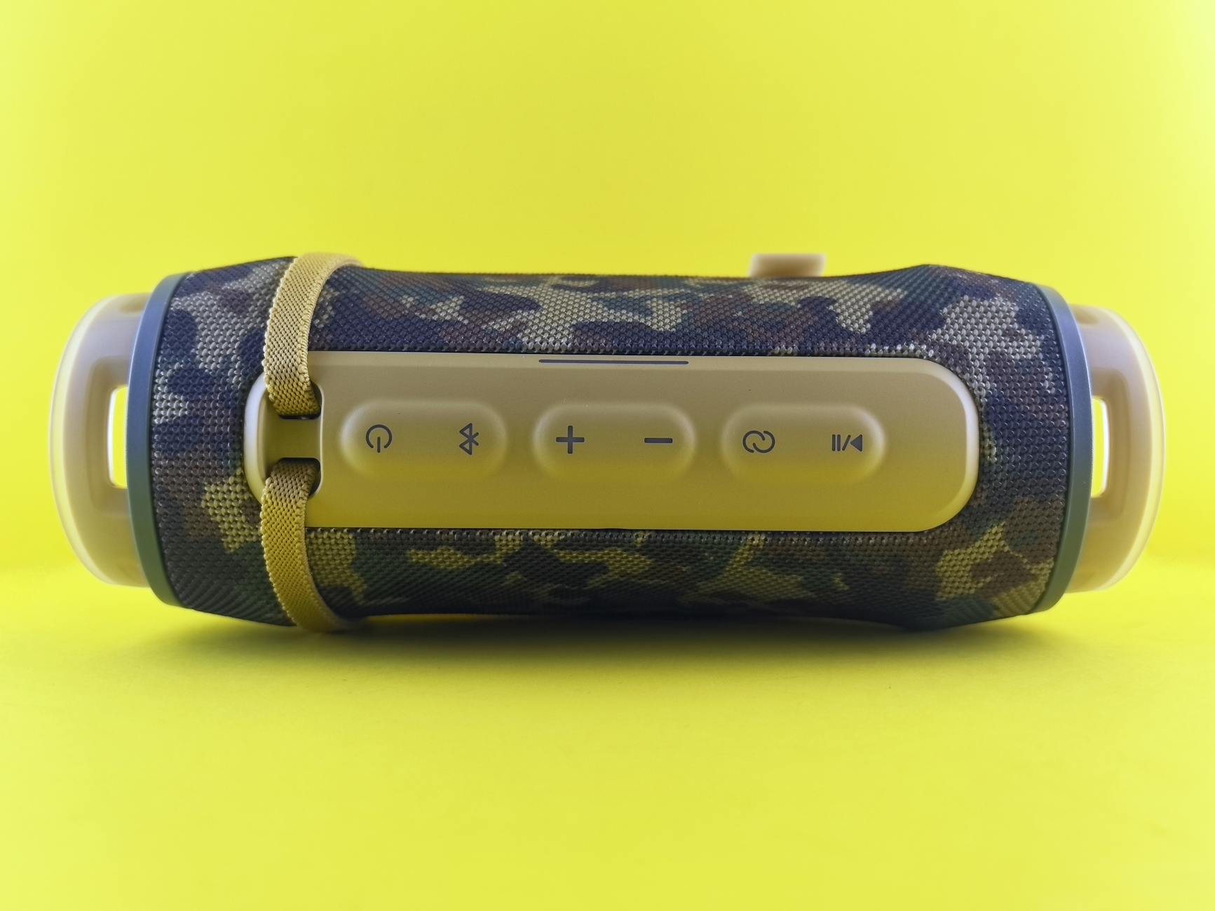 A stylish portable Bluetooth speaker with a camouflage design on a vibrant yellow background.